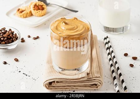 Le café Dalgona dans un verre transparent avec des pailles sur une serviette Banque D'Images