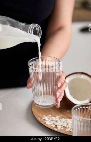 Verser du lait de coco maison dans le verre Banque D'Images