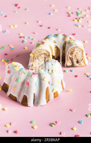 Gâteau Bundt avec glaçure blanche et saupoudrer de sucre en forme de coeur coloré pour la Saint-Valentin Banque D'Images