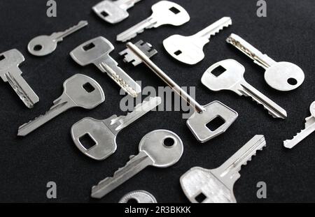 Variété de types de clés métalliques disposées dans l'ordre isolé sur la vue d'angle noir Banque D'Images