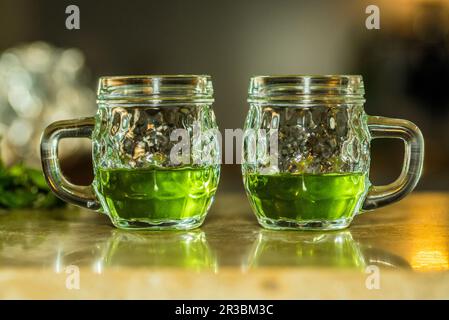 Absinthe verte dans des verres avec poignées Banque D'Images