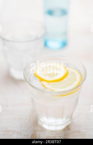 Eau fraîche dans un verre avec des glaçons et des tranches de citron Banque D'Images