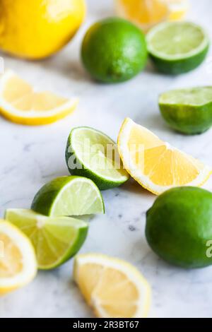 Citrons et limes, entiers, coupés en deux et en tranches Banque D'Images