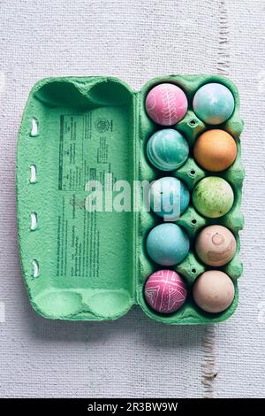 Œufs de Pâques teints en couleurs pastel dans une boîte à œufs Banque D'Images