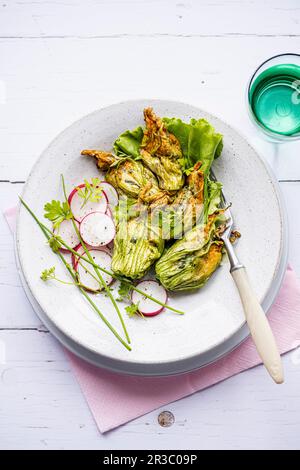 Fleurs de courgettes farcies avec salade de radis Banque D'Images