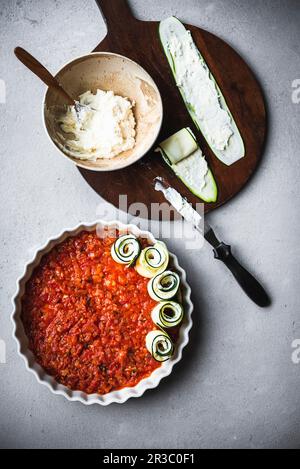 Préparation des petits pains de courgettes avec de la ricotta, du citron et de la sauce tomate Banque D'Images