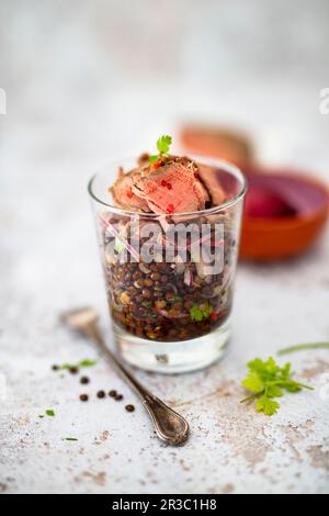 Dans un pot, mettre en salade les lentilles de béluga et les filets de bœuf Banque D'Images