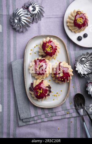 Mini tartelettes végétaliennes avec garniture au yogourt au soja aux myrtilles et pistaches Banque D'Images