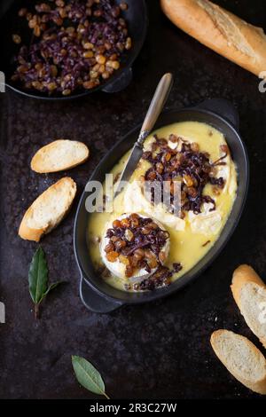 Camembert cuit au four avec des sultanines et des oignons caramélisés Banque D'Images