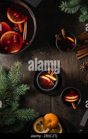 Vin chaud dans des tasses avec des tranches d'orange sur une table en bois Banque D'Images