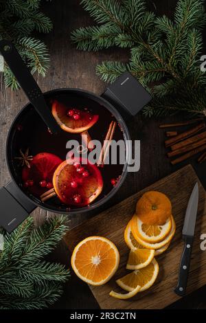 Vin chaud accompagné de tranches d'orange et d'épices dans une casserole Banque D'Images