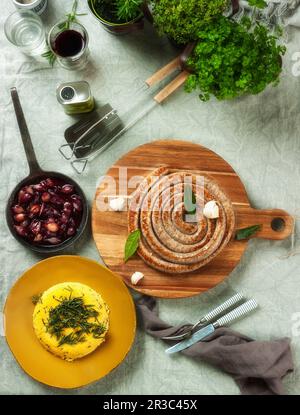 Une spirale de saucisses grillées avec polenta et échalotes balsamiques Banque D'Images