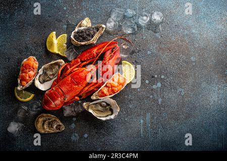 Assiette de fruits de mer avec homard entier rouge cuit, huîtres fraîches ouvertes, caviar noir et tartare de saumon Banque D'Images