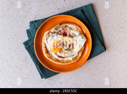 Paratha avec yaourt à l'ail, œuf frits, bacon et huile de Chili Banque D'Images