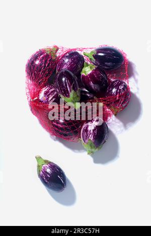 Aubergines à rayures violettes et blanches dans un filet Banque D'Images