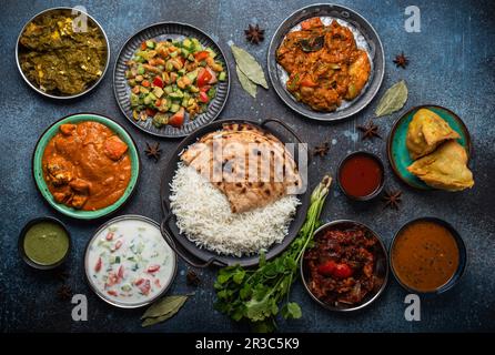 Buffet de plats indiens variés sur béton rustique Banque D'Images