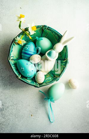 Cadre de Pâques avec jonquilles et œufs sur fond de béton Banque D'Images