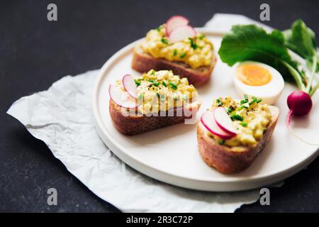 Pain avec salade d'oeufs, garni de radis et de ciboulette Banque D'Images