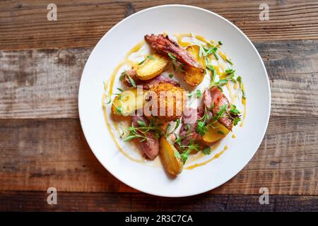 Un œuf de Scotch avec du bacon, des pommes de terre, de la vinaigrette au citron et des herbes Banque D'Images