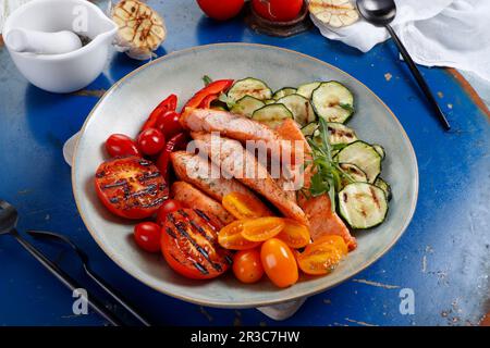 Morceaux de saumon cuits servis avec des légumes grillés Banque D'Images