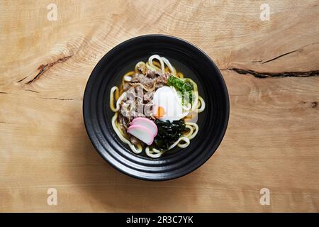 Ramen avec des nouilles udon, du bœuf râpé, des algues et un œuf Banque D'Images