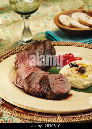 Filet de bœuf grillé et purée de pommes de terre dans un cadre méditerranéen Banque D'Images