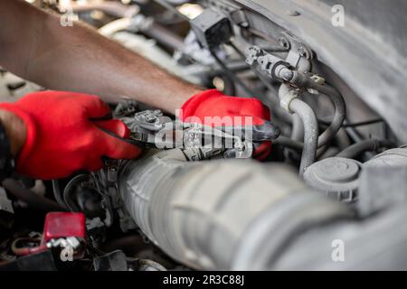 Réparations de voitures. Le mécanicien déconnecte le tuyau d'air du moteur de la voiture. Banque D'Images