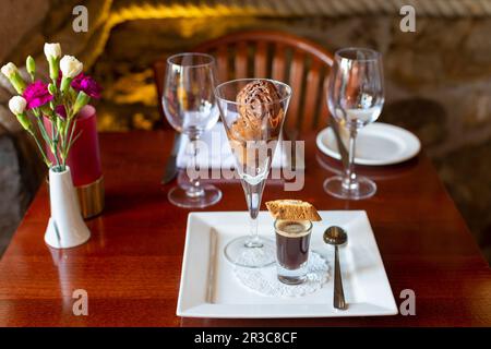Liqueur de café avec biscotti et sundae au chocolat avec caramel Banque D'Images