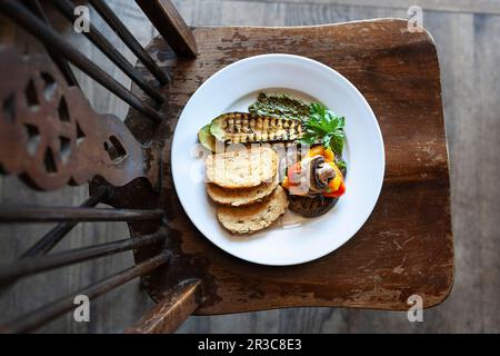 Légumes grillés (aubergines, courgettes, champignons, poivrons) avec du pesto et du pain soda sur un tabouret en bois Banque D'Images