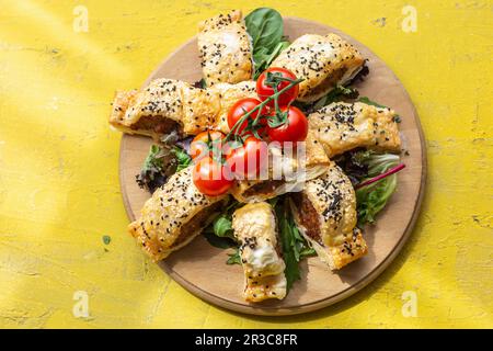 Saucisses en pâte servies avec des tomates et des feuilles de laitue Banque D'Images