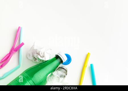 Plastique déchets danger écologie concept avec déchets et pailles colorées à usage unique, tasses à couverts, bouteilles sur fond blanc Banque D'Images