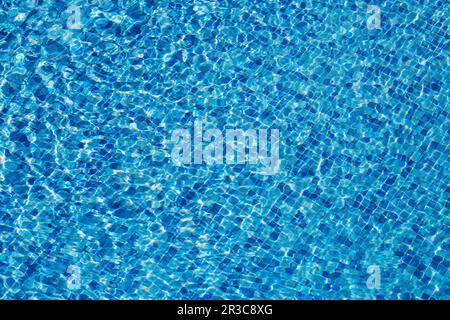 Les caustiques du fond de la piscine se ondulent et s'écoulent avec la texture de fond des vagues Banque D'Images