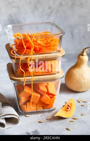 Boîtes en verre avec légumes frais d'orange crus. Citrouille et gros morceaux déchiquetés. Repas sain P Banque D'Images