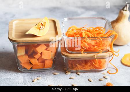 Boîtes en verre avec légumes frais d'orange crus. Citrouille et gros morceaux déchiquetés. Repas sain P Banque D'Images