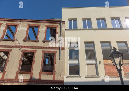 Une ancienne maison en besoin de rénovation se trouve à côté d'une maison récemment rénovée Banque D'Images