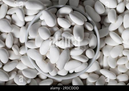 Bonbons aux amandes. Bonbons aux amandes enrobés de sucre dans un bol en céramique. Petites friandises multicolores. Vue de dessus Banque D'Images