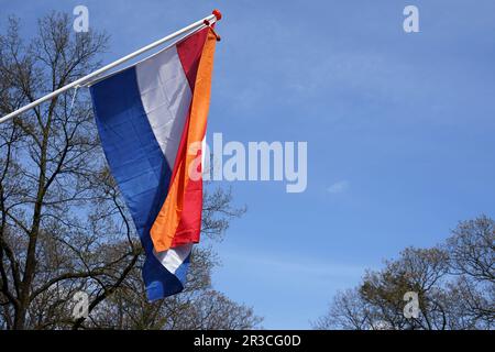 Drapeau hollandais en rouge, blanc et bleu, avec un pennon orange derrière le drapeau le jour de la célébration nationale néerlandaise Koningsdag (le jour du Roi) à 27 avril Banque D'Images