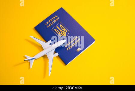 Kiev, Ukraine - 25 novembre 2020: Gros plan passeport biométrique ukrainien avec avion jouet à proximité Banque D'Images