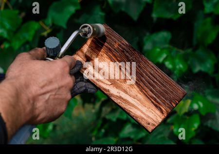 Travailler avec le bois. Traitement du bois avec feu. Brûleur à gaz Banque D'Images