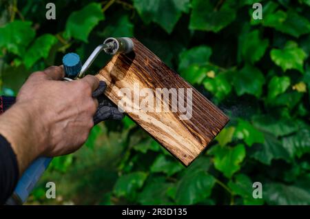 Travailler avec le bois. Traitement du bois avec feu. Brûleur à gaz Banque D'Images