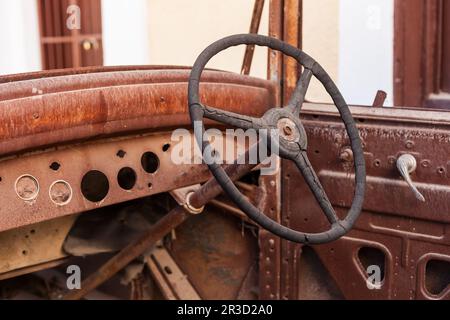 Old rusty motor car volant dans un parc à ferrailles Banque D'Images