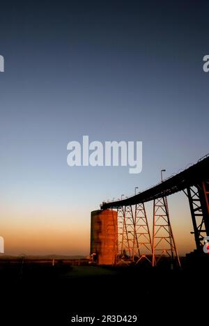 Silhouette d'un silo minier et de tapis transporteurs Banque D'Images