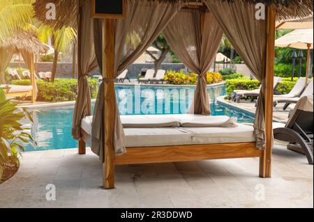 Bungalow à côté de la piscine bleue dans la station de l'hôtel par beau soleil Banque D'Images