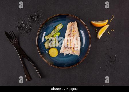 Dîner de fruits de mer luxueux. Percher le filet de poisson avec les légumes sur le noir. Banque D'Images