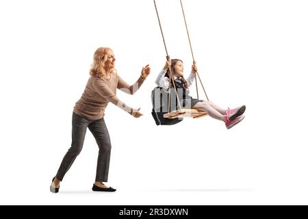 Femme poussant une écolière sur une balançoire isolée sur fond blanc Banque D'Images