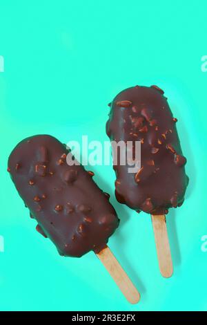 Gâteau - popsicle en glaçage au chocolat sur fond bleu. espace pour le texte. Crème glacée eskimo sucrée avec glaçage au chocolat. Chocolat Banque D'Images