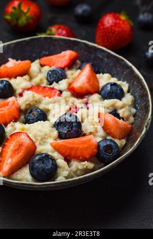 Le concept d'un petit déjeuner sain de flocons d'avoine avec des fraises et des bleuets Banque D'Images