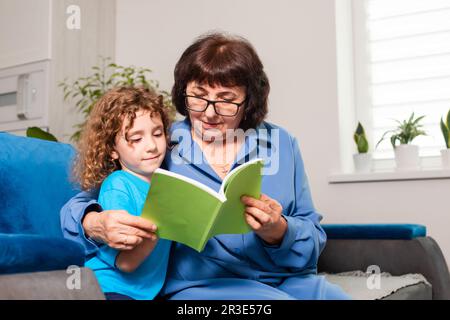 Grand-mère et petite fille lisant le livre ensemble Banque D'Images