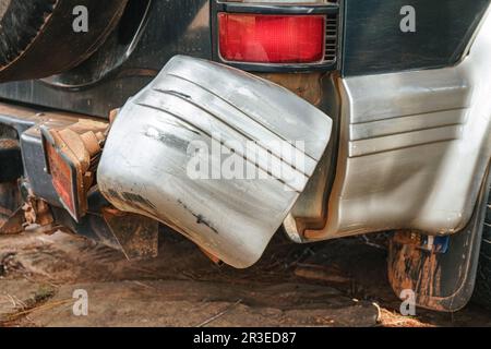 Feu arrière cassé, sale de la poussière rouge, du véhicule tout-terrain 4x4, pare-chocs en plastique rayé et incliné Banque D'Images