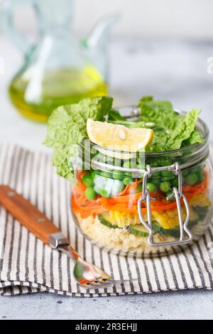 Bol en verre avec légumes frais crus et gruaux couscous. Préparation de repas sains - photos de préparation de recettes. Plats végétariens sains Banque D'Images
